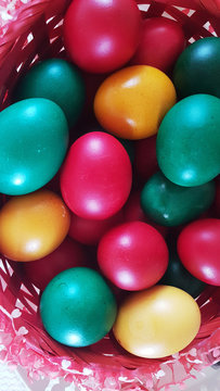 eggs colored for easter red green and yellow in a basket