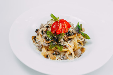 Italian pasta in a creamy sauce with mushrooms champignon on a white plate