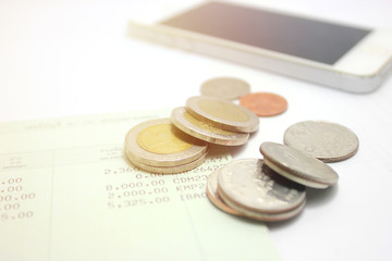 coins and phone on account book bank for finance and banking. (Business concept)