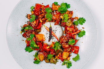 spicy salad with chili peppers and pieces of chicken with rice on a white background