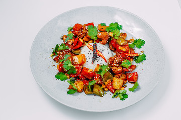 spicy salad with chili peppers and pieces of chicken with rice on a white background