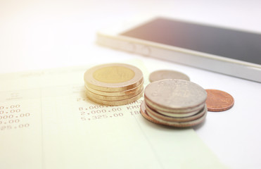 coins and phone on account book bank for finance and banking. (Business concept)
