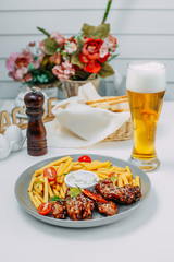 Fototapeta na wymiar spicy chicken wings with french fries and sauce on an isolated white background