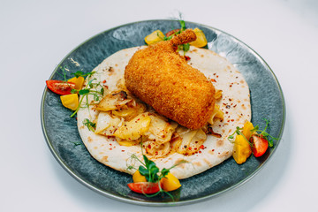 breaded chicken leg with fried potato wedges and pita bread on an isolated white background