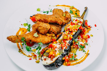 breaded chicken with stuffed eggplant and pepper on an isolated white background