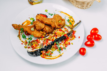 breaded chicken with stuffed eggplant and pepper on an isolated white background