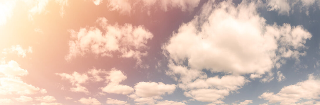 Beautiful Landscape Of Blue Cloudy Sky With Warm Sunny Tonings. Warm And Soft Sunlight Illuminate Sky. Ultra-wide Panoramic Natural Background