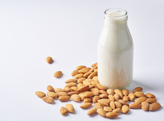 almonds and a bottle of almond milk on a white background. Vegan milk.