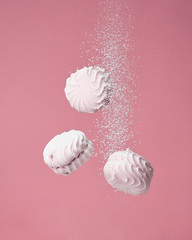  Soaring pink zephyr marshmallow on pink background. flying food levitation, sweet candy dessert.