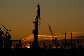 Hafenkräne und Industrie vor Sonnenuntergang