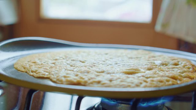 Flapjack, tortilla, pizza, bake fry pan cake on gas stove. Close up. Side view.