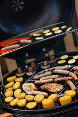 grill with potatoes, turkey meat, zucchini, mushrooms and sausages