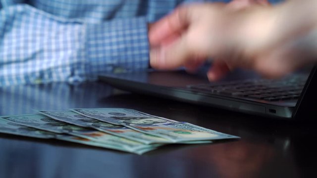 Crop female boss paying salary to office worker in US dollars