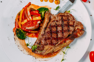 grilled beef steaks with spices isolated on white background