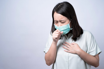 Young Asian women wearing masks, She is ill with a cold and sneezing, Isolated on white background.