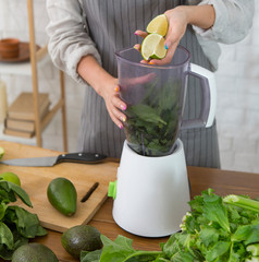 Woman using blender to make pesto. Vegetarian, clean eating