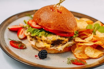 burger with beef patty and potato chips on a white decorated table