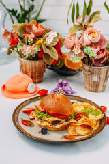 burger with beef patty and potato chips on a white decorated table