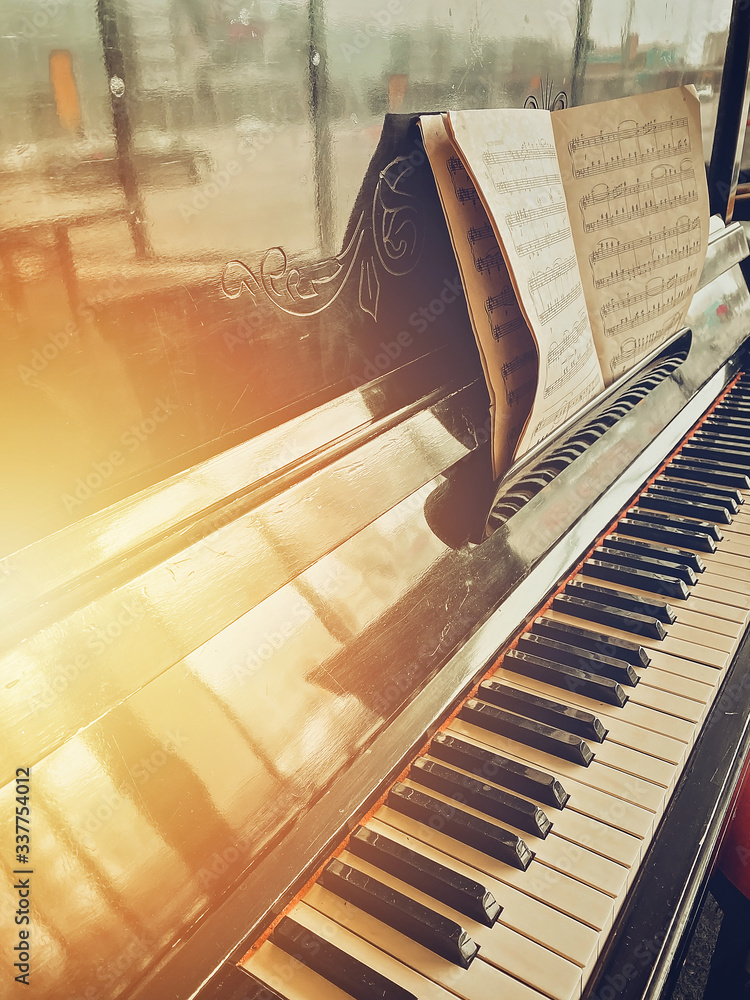 Wall mural old piano and sheet music. side view. toning. mobile photography. vertical shot for social networks