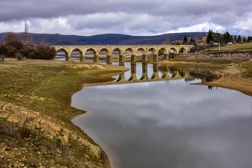 Fototapeta na wymiar lake crossed by a bridge and its reflection