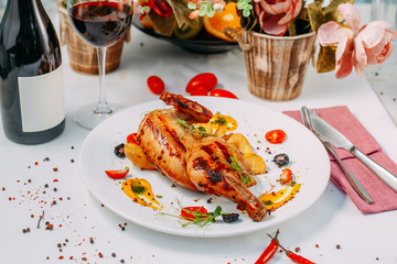 grilled chicken with potatoes on a decorated white table