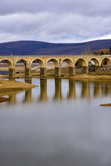 Fototapeta premium lake crossed by a bridge and its reflection