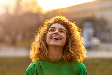Portrait of young woman with curly hair in the city
