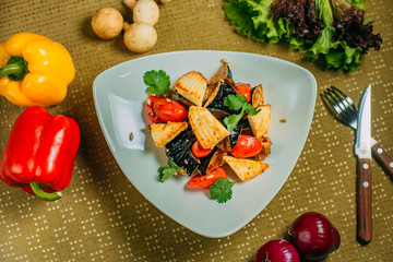 salad with eggplant and tofu and tomatoes, healthy food on a decorated table