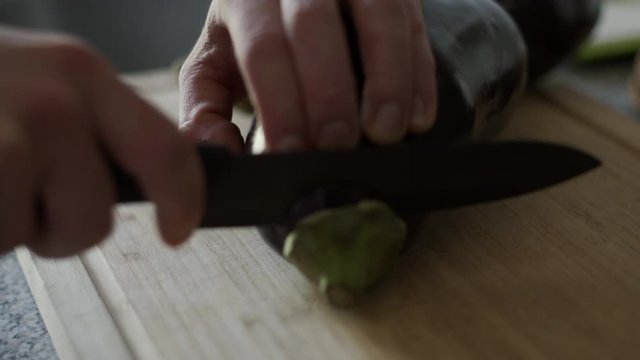 Cutting an eggplant on a chopping board