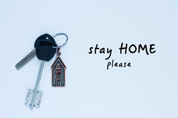 bundle of keys with a keychai in in the form of a house. Inscription stay home please