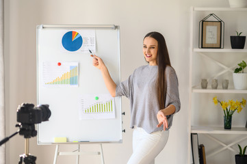 Young woman with flipchart records video lessons