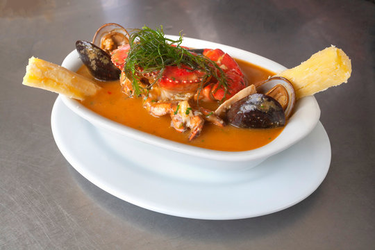Peruvian seafood: Parihuela or special seafood soup with crab, mussels and cassava, decorated with seaweed and served on a white bowl