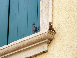 Metal  decorative support for wooden shutters in a three-story house in the old part of Verona city in Italy.