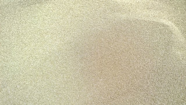 Background of golden nano sand at a technology exhibition. Light tone. Place for your text. Copy space. Cream color, ivory, champagne. Idea for decor. Yellow wallpaper. Texture effect.