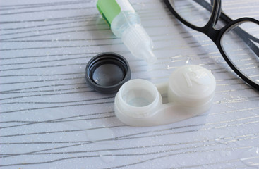 Contact lenses in container, bottle with solution, glasses - 337760426