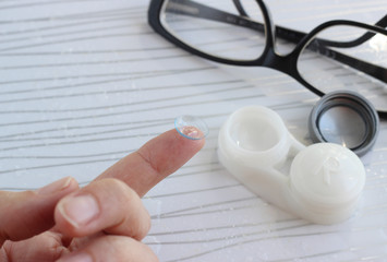 Female finger with contact lens - 337760469