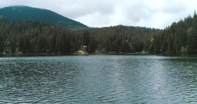 Mountain lake with turquoise water and green trees. Drone view of Lake Synevir in Carpathian Mountains in Ukraine. 4k video. 