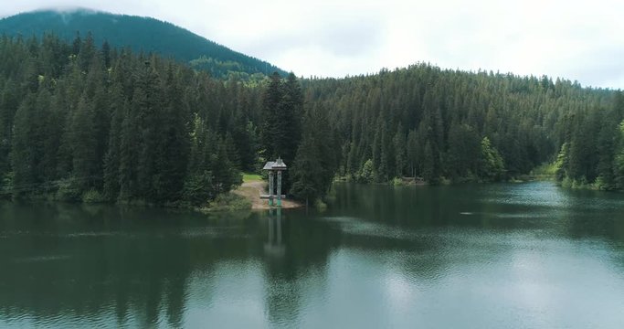 Mountain lake with turquoise water and green trees. Drone view of Lake Synevir in Carpathian Mountains in Ukraine. 4k video. 