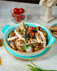 оven baked chicken and potatoes with tomatoes and peppers top view