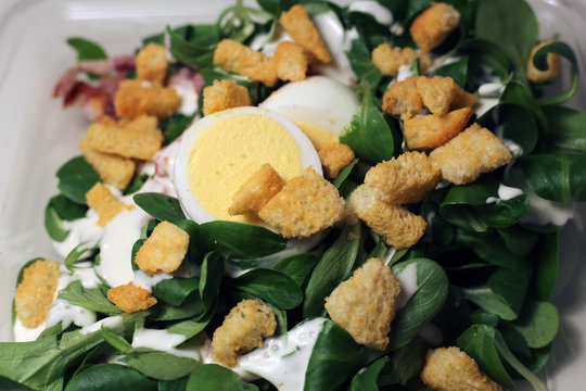 "Nüsslisalat" salad photographed in Baden Switzerland, March 2020. This takeaway grocery store salad includes some greens, egg, croutons, bacon and dressing. Healthy and delicious food to eat on go. 