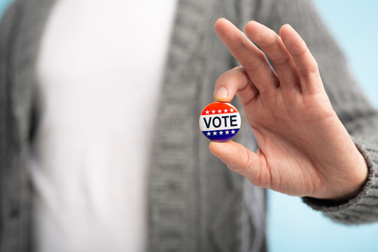 Man With Vote Pin In Hand On Blurred Background