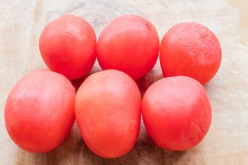 Red tomatoes on the brown wood.