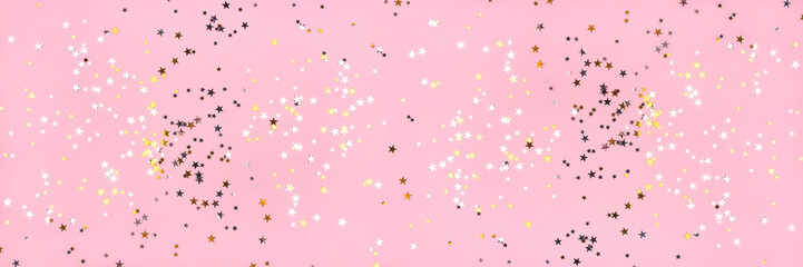 Golden and silver stars on pink pastel background. Flat lay, top view.