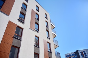 Modern and new apartment building on a sunny day with a blue sky. Contemporary residential building exterior in the daylight.