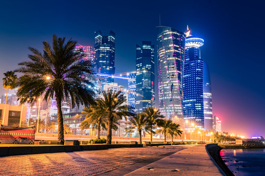 Night view on the centre of the city Doha, Qatar with many modern luxury building and skyscrapers illuminated with bright lights.
