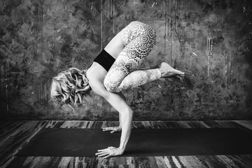 Young blonde woman practicing yoga at home.