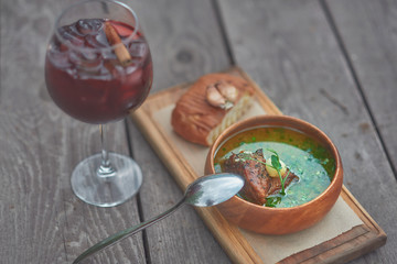 meat soup with a large piece of meat on an old wooden table