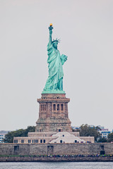 Obraz premium Statue of Liberty on Liberty Island during the gloomy weather in New York.