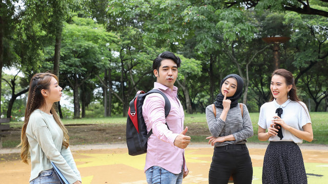 Young Asian Malay Chinese Man Woman Outdoor Park Walk Stand Study Talk Discuss Point Laptop File Book Backpack Male Thumbs Up