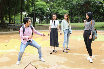 Young asian malay chinese man woman outdoor park walk stand study talk discuss point laptop file book backpack fun play